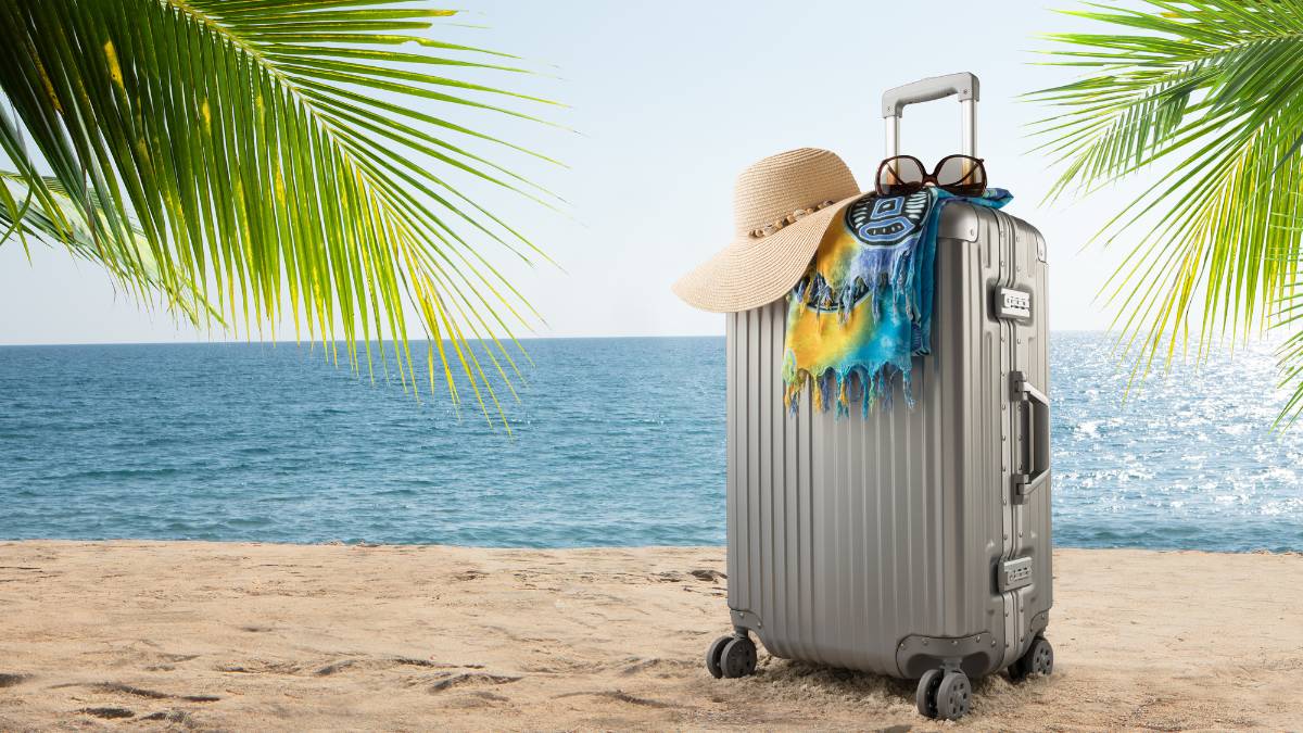 mala de viagem cinza na praia
